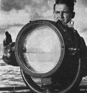 A Navy signalman uses one of the Service's signal searchlights - RF Cafe